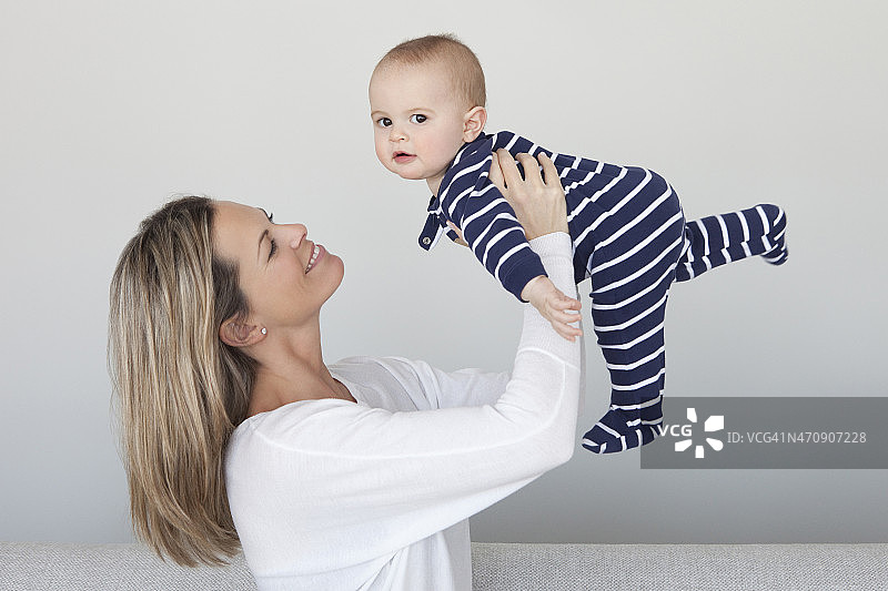 母亲将她的男婴高高举起图片素材