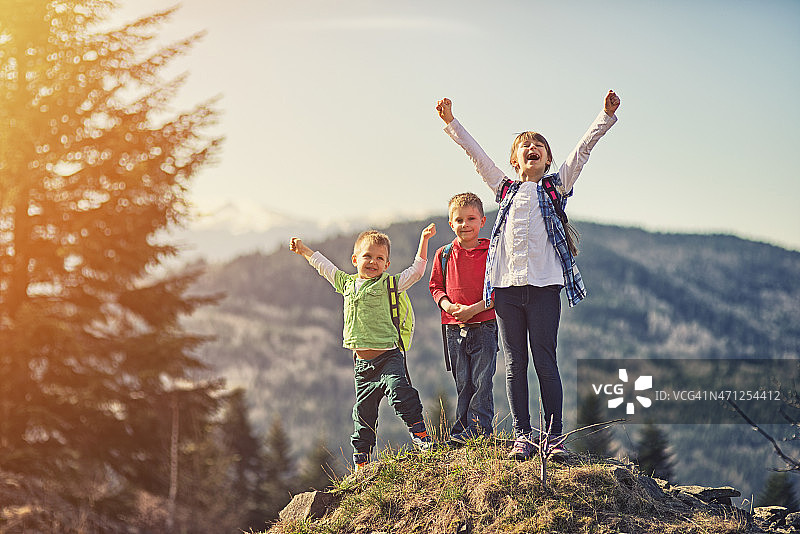 到达山顶后欣赏风景的小登山者图片素材