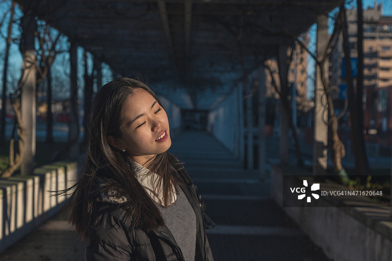 在城市街道摆姿势的年轻漂亮的中国女孩图片素材