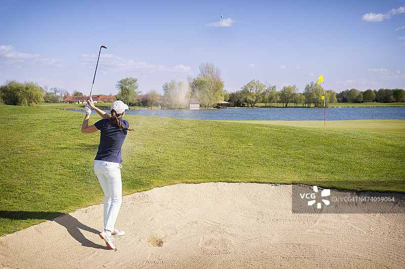 高尔夫球手从沙坑切球图片素材