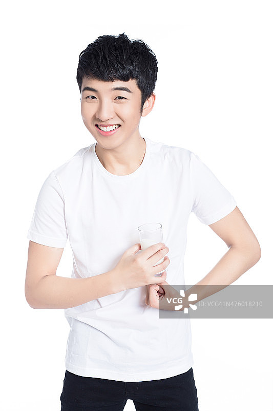微笑青年拿着一杯牛奶摆姿势图片素材