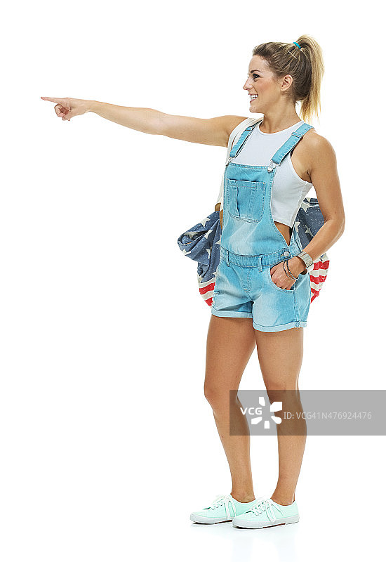 面带微笑指向远方的休闲女士图片素材