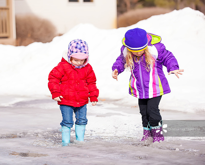 在春天水坑里玩耍的女孩们图片素材