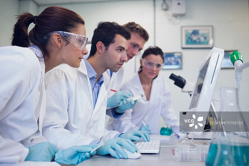 在实验室里看电脑屏幕的研究人员图片素材