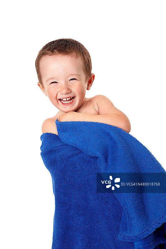 裹着蓝色毯子，微笑的可爱男婴图片素材