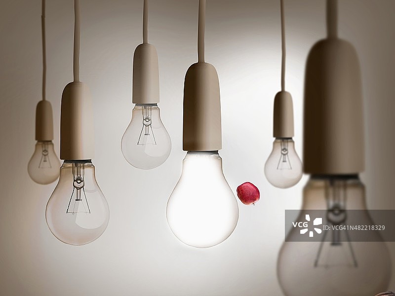 红色苹果在灯泡间抛掷图片素材