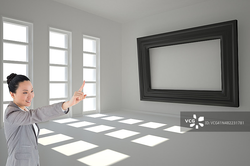 微笑的亚洲女商人指着的合成图像图片素材