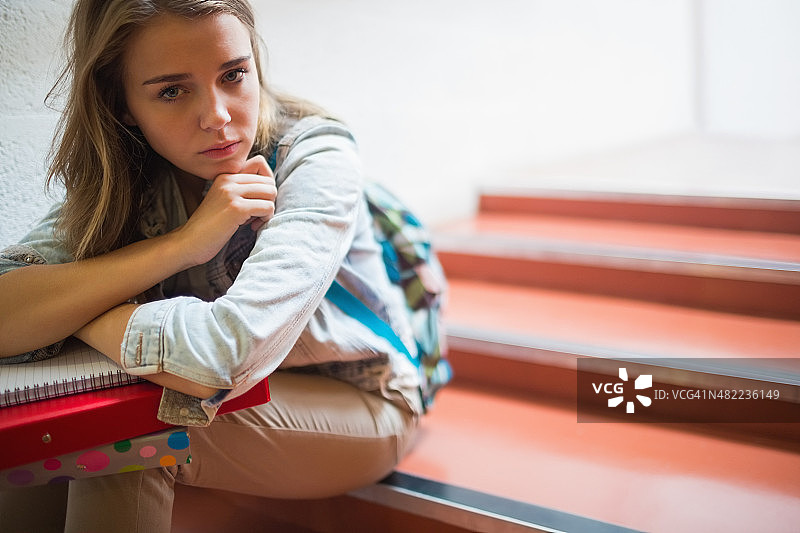 孤独的学生坐在楼梯上看镜头图片素材