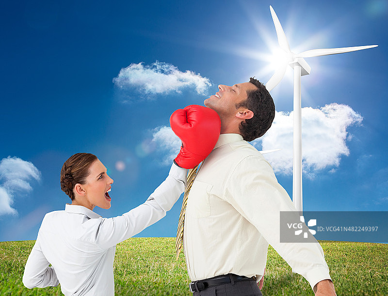 商务女性戴拳击手套击打男商人的合成图像图片素材