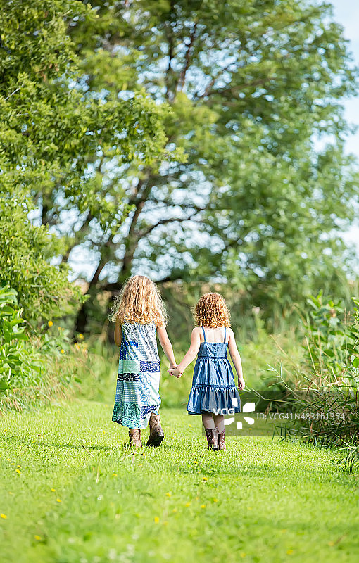两姐妹手牵手走路的背影图片素材
