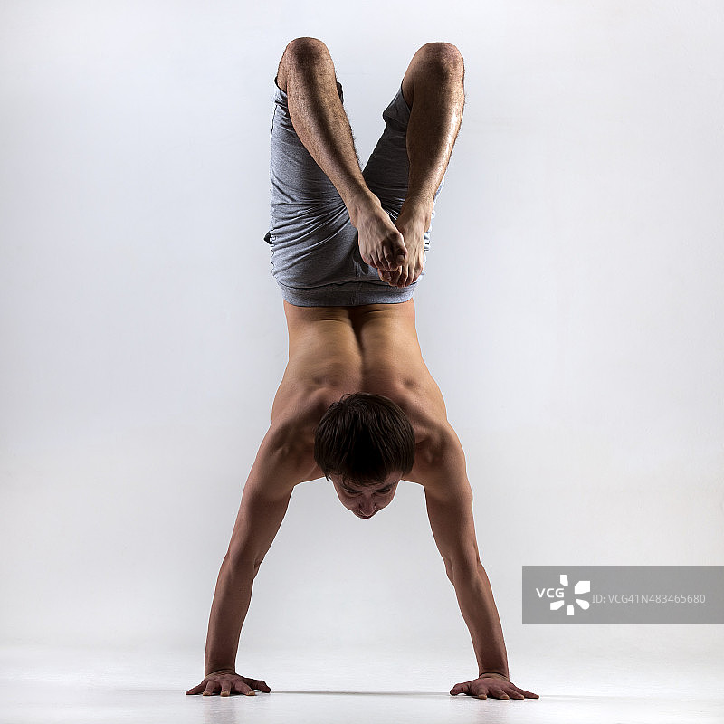 练习蝎子式的瑜伽男子，后视图图片素材