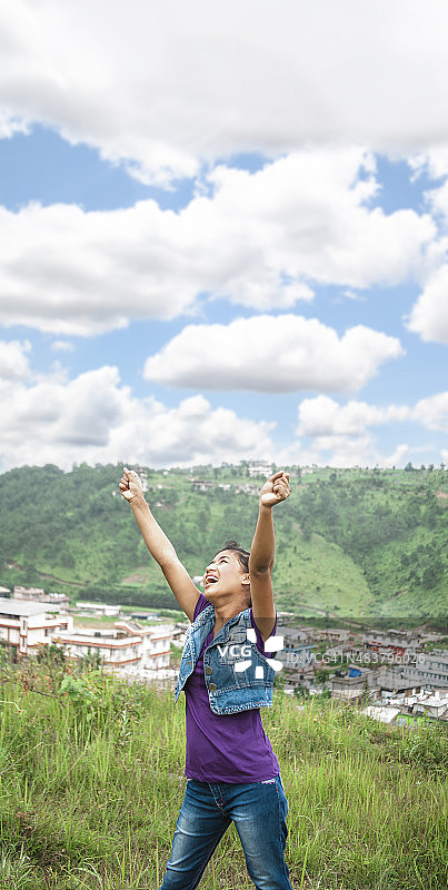 赞美！亚洲女孩举起双臂表示感谢。图片素材