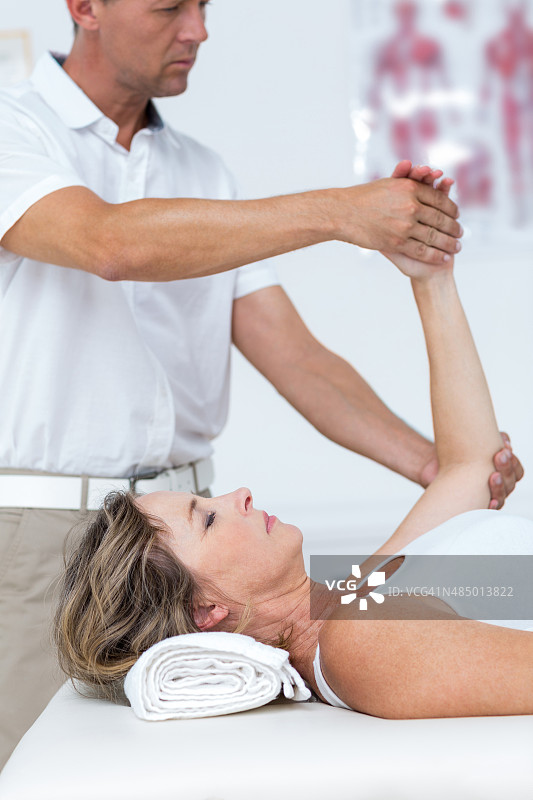 医生弯曲患者手臂图片素材