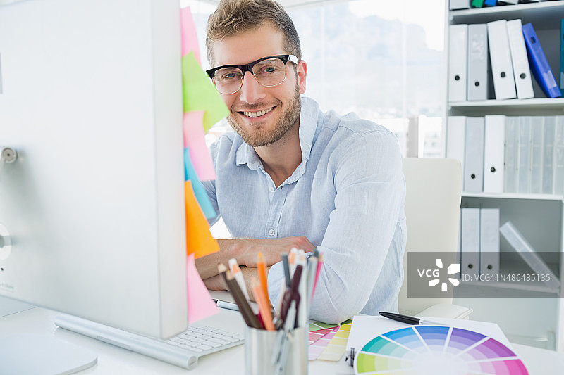 使用电脑的微笑的年轻男人的肖像图片素材