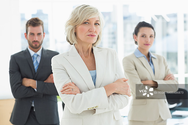 在办公室里双臂交叉的自信商务团队图片素材