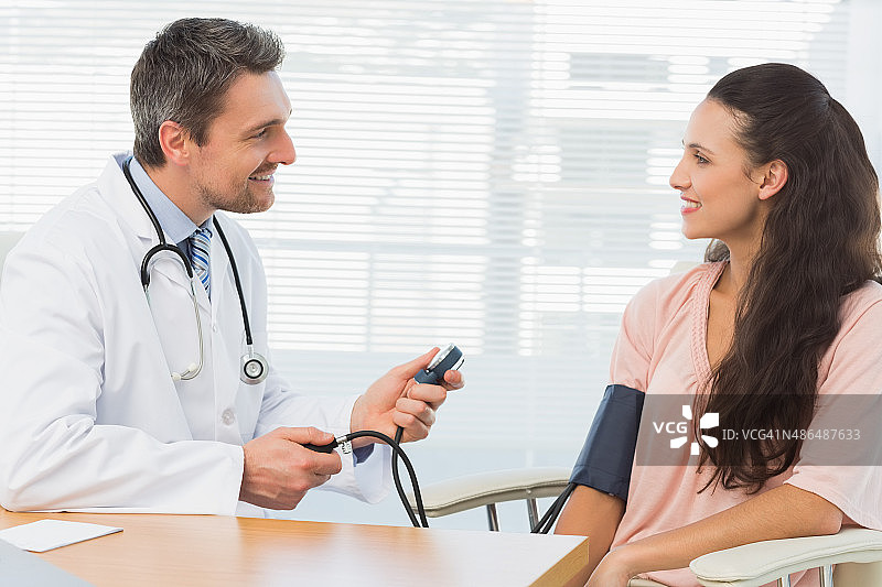 男医生为年轻女子检查血压图片素材