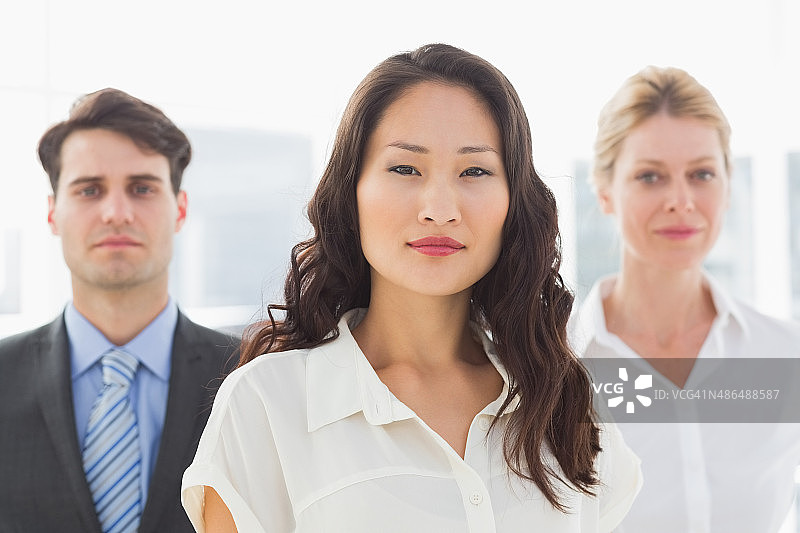 严肃的女商人站在她的团队面前图片素材