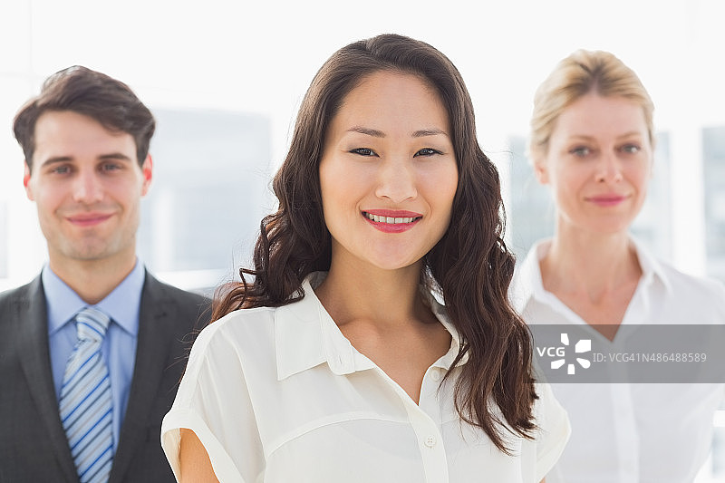 快乐的女商人站在团队前图片素材