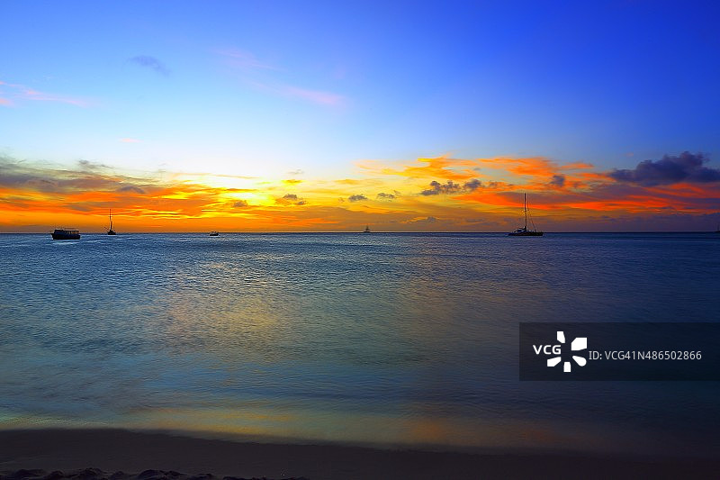 阿鲁巴天堂：绿松石海滩、船只和绚丽多彩的日落——加勒比安的列斯群岛图片素材