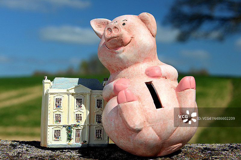 快乐的储蓄罐和小房子/娃娃屋图片素材