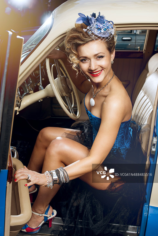 在复古汽车前摆姿势的女人图片素材