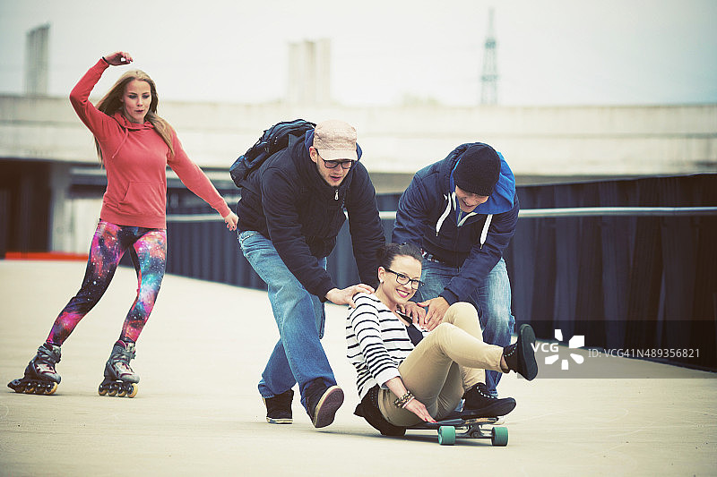 一群青少年在户外玩滑板和轮滑图片素材