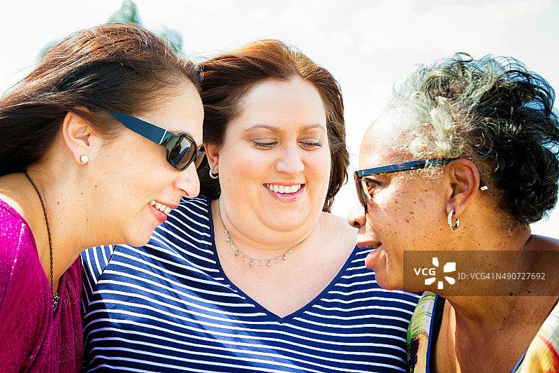 在户外开心地闲聊的三位中年女性图片素材