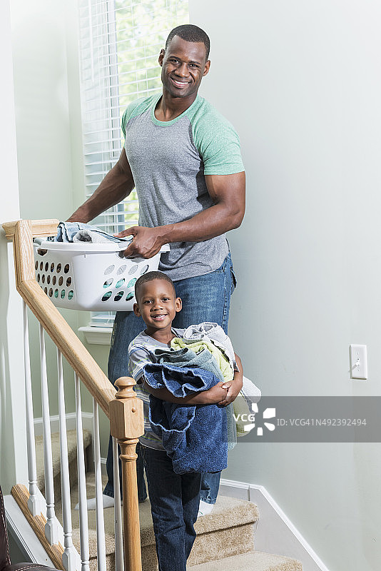 非裔美国小男孩帮助父亲洗衣服图片素材