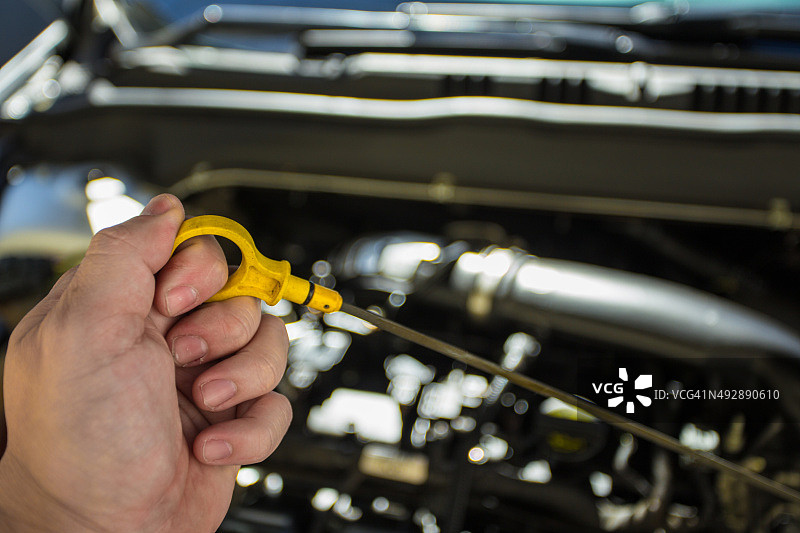 用手取出油尺的汽车发动机图片素材