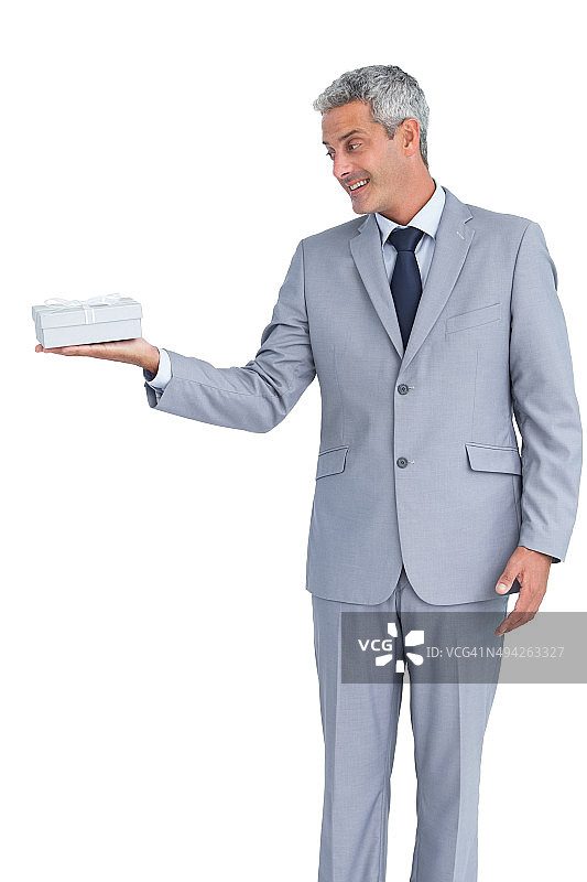 右手拿着礼物的英俊商人图片素材