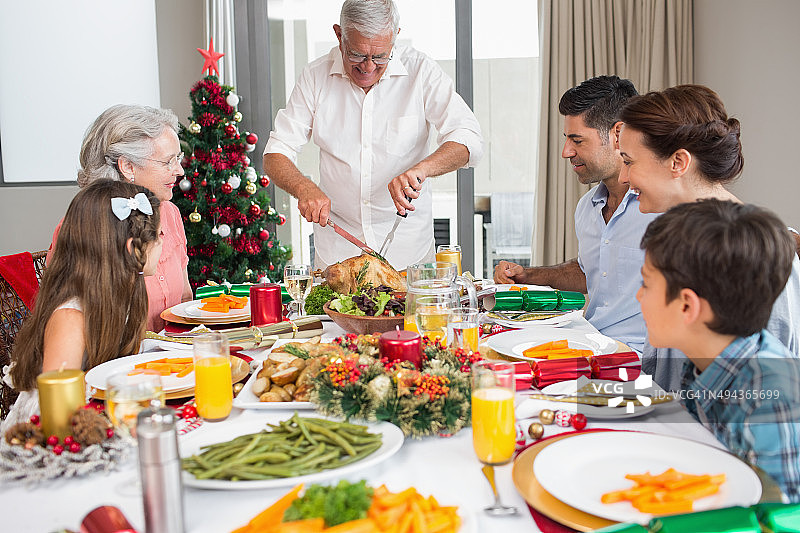 圣诞晚餐时在餐桌旁的大家庭图片素材