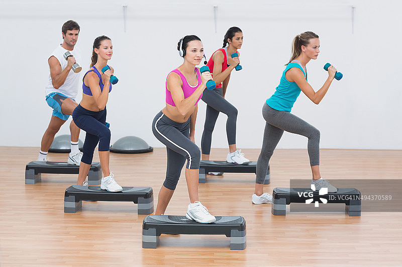 健身课上用哑铃进行踏板操图片素材