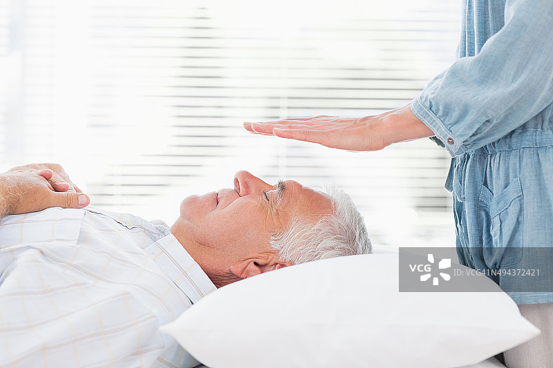 理疗师为老年男性进行灵气疗法图片素材