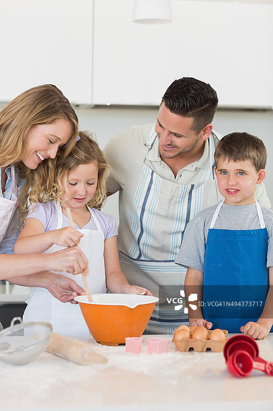 父母帮助孩子们烘烤饼干图片素材