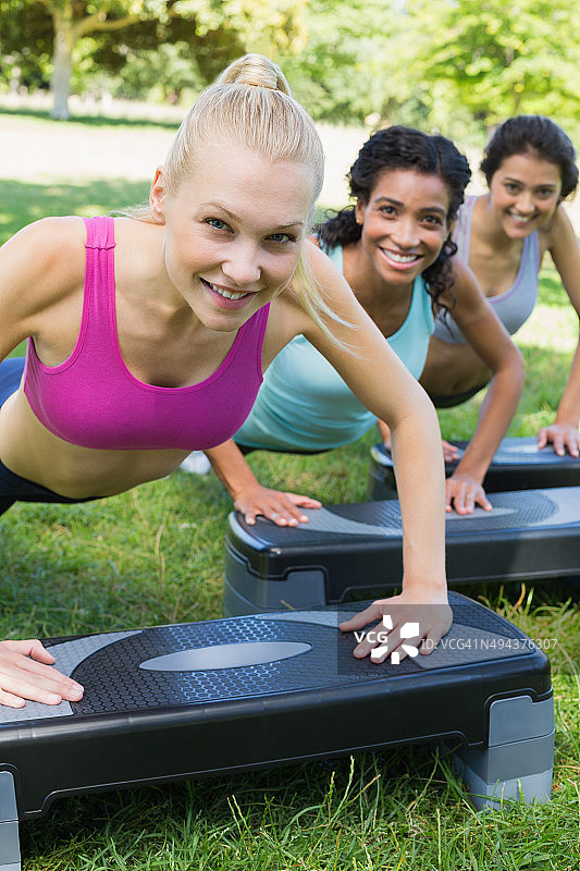 微笑的女人正在做踏步有氧运动图片素材