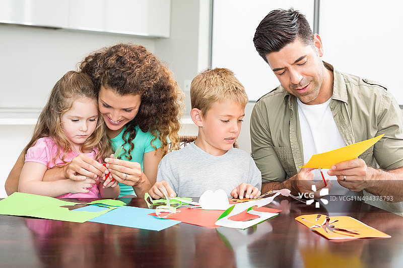 幸福的一家人在桌旁一起做手工图片素材