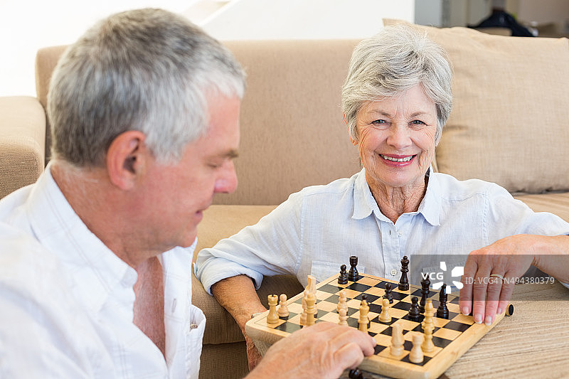 老年夫妇坐在地板上下棋图片素材