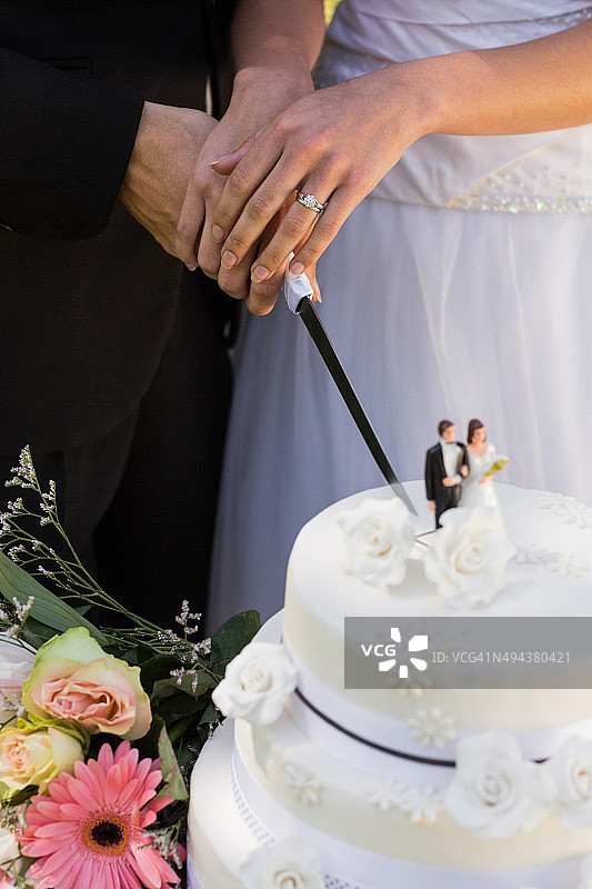 新婚夫妇切结婚蛋糕的中段镜头图片素材