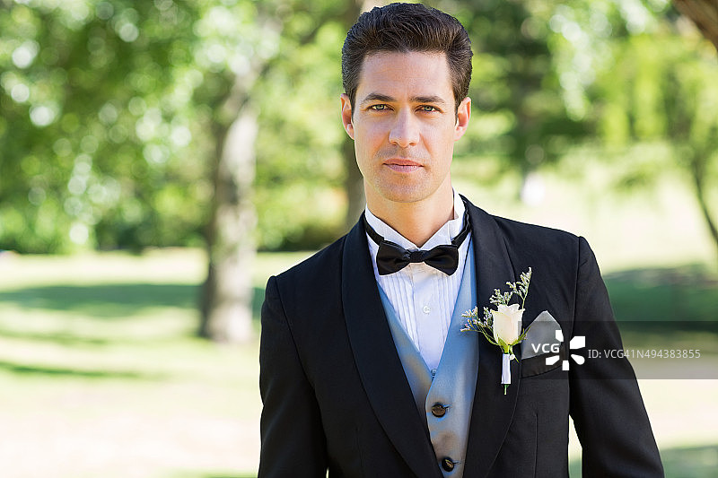 在花园里穿着燕尾服的自信新郎图片素材
