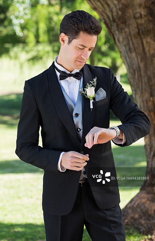 新郎在花园查看时间图片素材