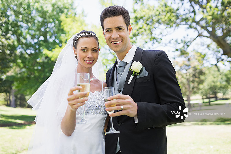 新婚夫妇在公园里举杯庆祝图片素材