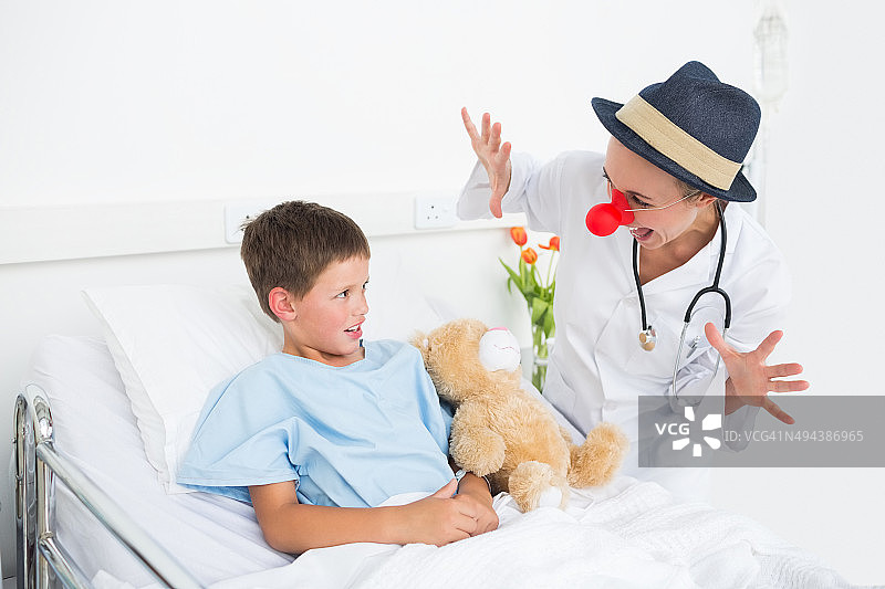小丑医生在医院里逗生病男孩开心图片素材