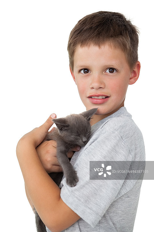 小男孩抱着灰色小猫对着镜头微笑图片素材