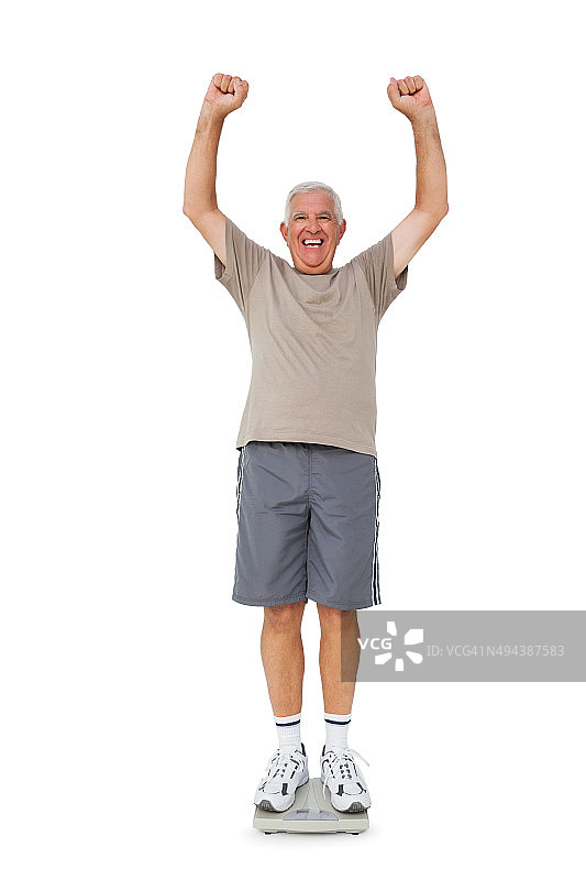 年长的男人在体重秤上欢呼图片素材