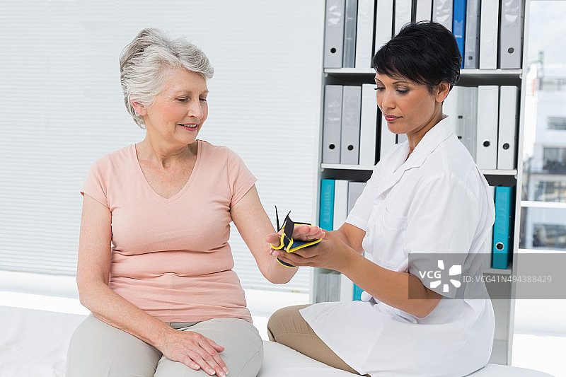 医生为老年患者的手固定腕托图片素材