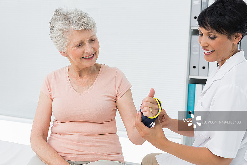 女医生为老年患者固定腕托图片素材