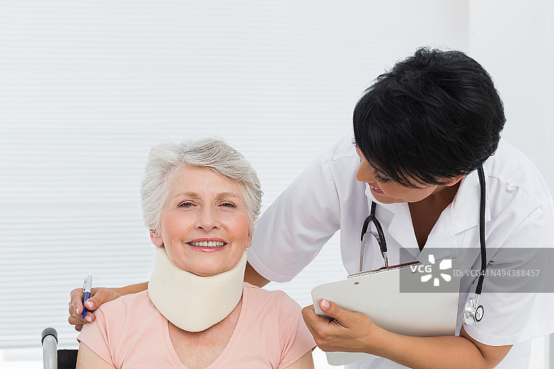 医生与戴着颈托的年长患者交谈图片素材