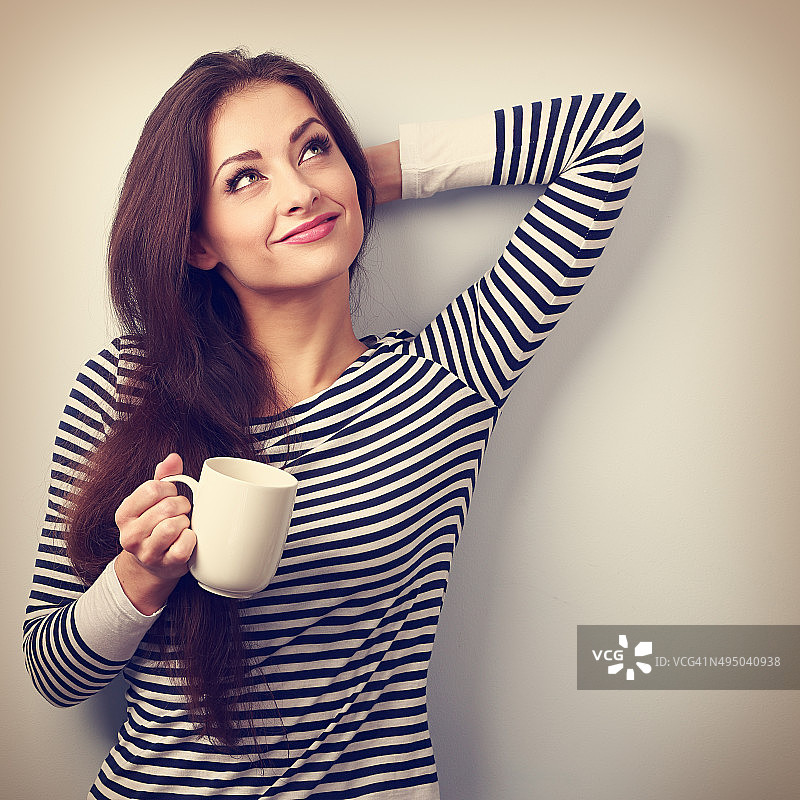 手持茶杯沉思的休闲有魅力女人图片素材