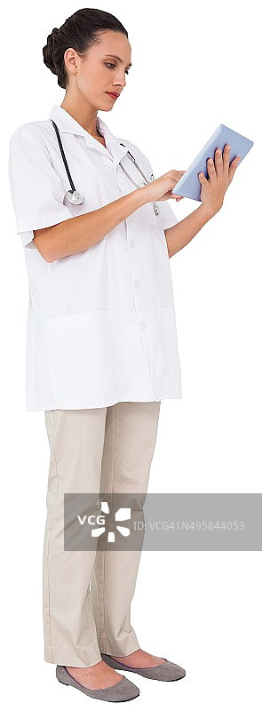 漂亮的棕发护士使用平板电脑图片素材