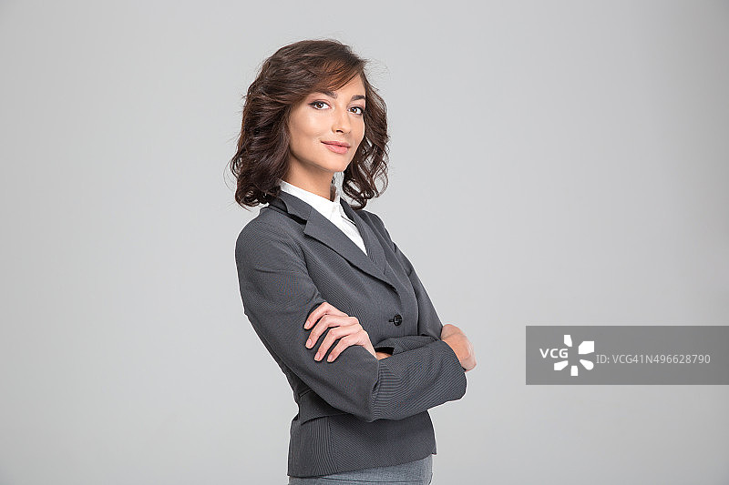 自信的年轻女人交叉双臂摆姿势图片素材